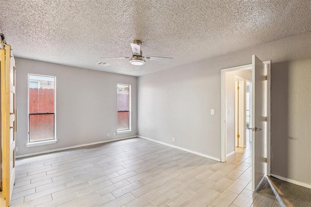 1909 Magnolia Ln, Edmond, OK 73013 - empty room featuring ceiling fan, wood finished floors, and a textured ceiling