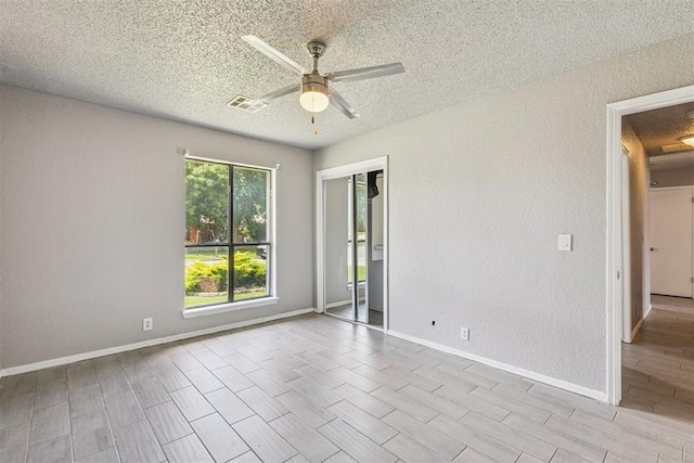 1909 Magnolia Ln, Edmond, OK 73013 - empty room with a textured ceiling, ceiling fan, wood finish floors, and a textured wall