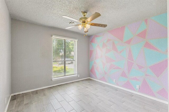 1909 Magnolia Ln, Edmond, OK 73013 - spare room with a ceiling fan, wood finished floors, and a textured ceiling