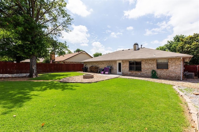 1909 Magnolia Ln, Edmond, OK 73013 - back of property with an outdoor fire pit, a fenced backyard, brick siding, and a patio