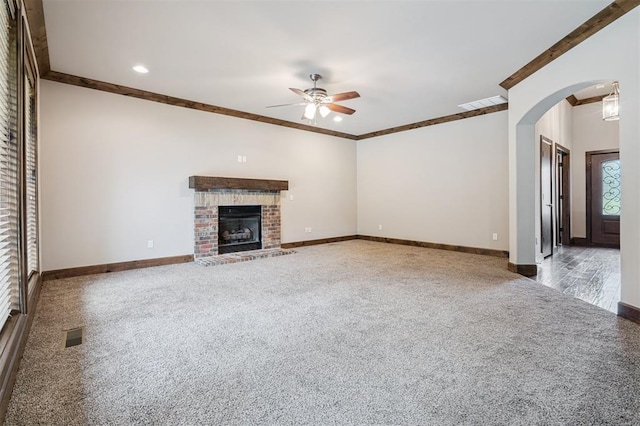 413 Branch Line Rd, Yukon, OK 73099 - unfurnished living room featuring carpet flooring, ceiling fan, crown molding, arched walkways, and a brick fireplace