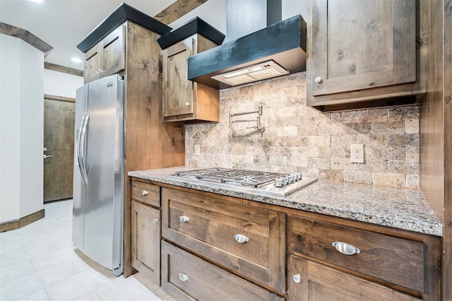 413 Branch Line Rd, Yukon, OK 73099 - kitchen with wall chimney range hood, appliances with stainless steel finishes, decorative backsplash, and light stone countertops