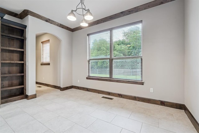 413 Branch Line Rd, Yukon, OK 73099 - unfurnished room featuring built in shelves, arched walkways, a chandelier, and light tile patterned floors
