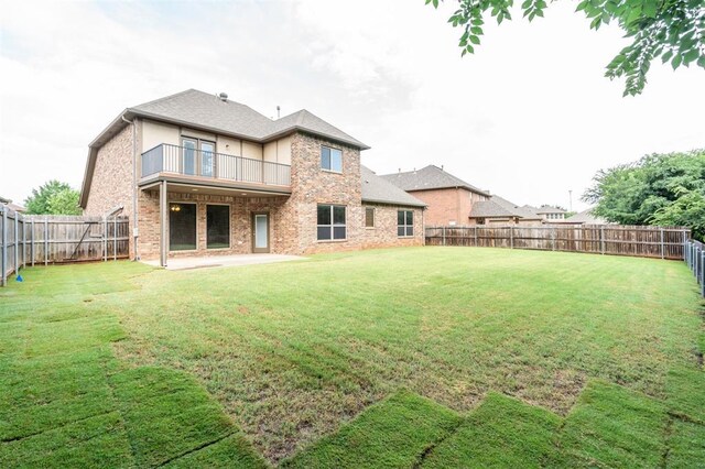 413 Branch Line Rd, Yukon, OK 73099 - rear view of house featuring a balcony, a fenced backyard, brick siding, and a patio area