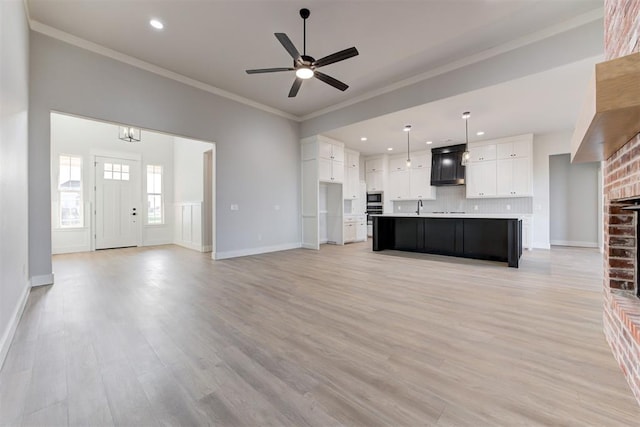 4337 Pinon Ln, Piedmont, OK 73078 - unfurnished living room featuring ornamental molding, recessed lighting, light wood finished floors, ceiling fan, and a brick fireplace