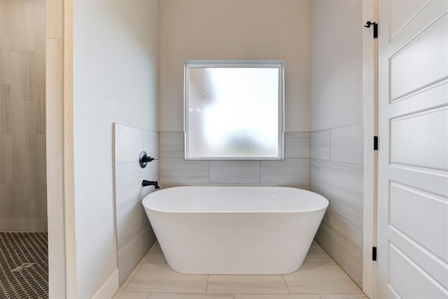 4337 Pinon Ln, Piedmont, OK 73078 - bathroom with a soaking tub, tile patterned floors, tile walls, tiled shower, and a wainscoted wall
