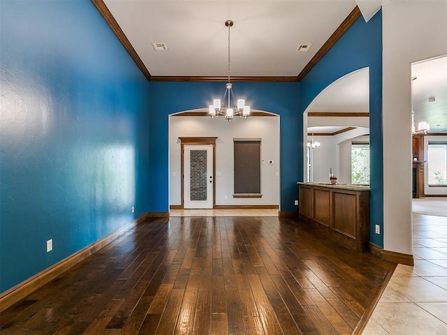 13705 Cascata Strada St, Oklahoma City, OK 73170 - foyer entrance with a chandelier, ornamental molding, hardwood / wood-style floors, and arched walkways