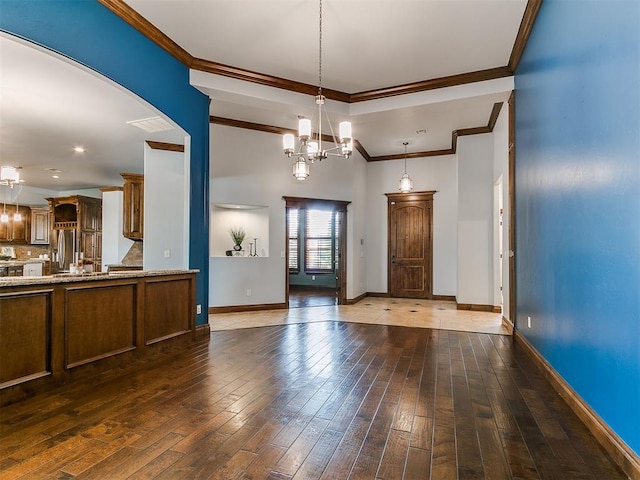 13705 Cascata Strada St, Oklahoma City, OK 73170 - unfurnished living room with ornamental molding, hardwood / wood-style floors, a chandelier, and arched walkways