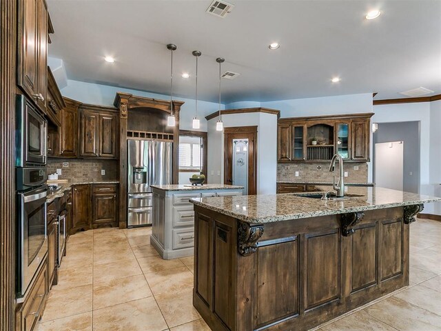 13705 Cascata Strada St, Oklahoma City, OK 73170 - kitchen featuring appliances with stainless steel finishes, a center island with sink, backsplash, and recessed lighting