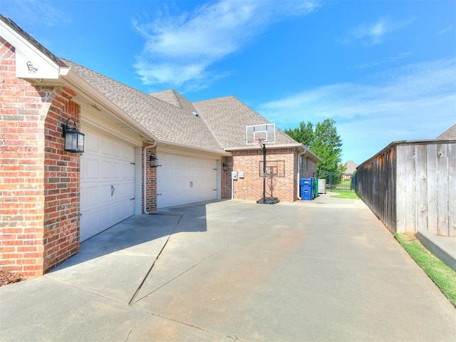 13705 Cascata Strada St, Oklahoma City, OK 73170 - view of property exterior featuring brick siding, concrete driveway, roof with shingles, and a garage