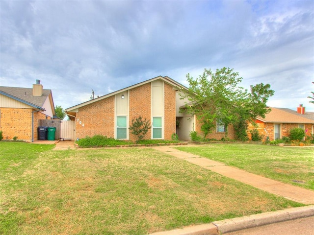 704 NW 137th St, Edmond, OK 73013 - view of front of property featuring brick siding, a front lawn, and a gate