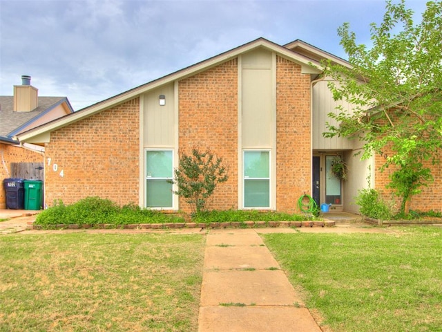 704 NW 137th St, Edmond, OK 73013 - view of front of home with a front yard and brick siding