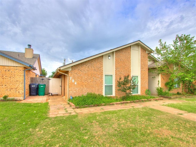704 NW 137th St, Edmond, OK 73013 - view of side of home with brick siding and a gate