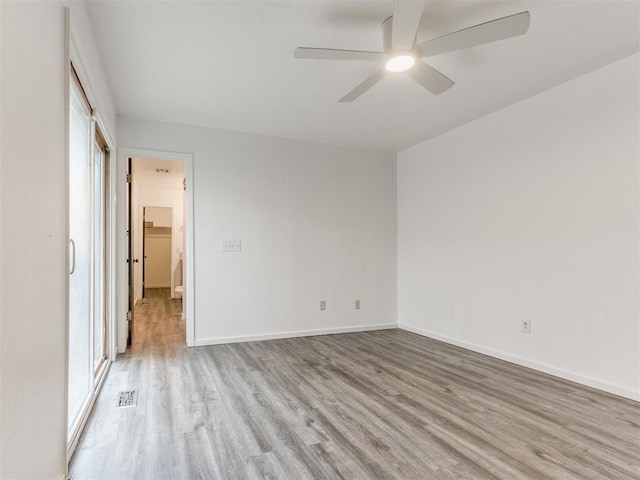 704 NW 137th St, Edmond, OK 73013 - unfurnished bedroom with wood finished floors, multiple windows, and ceiling fan