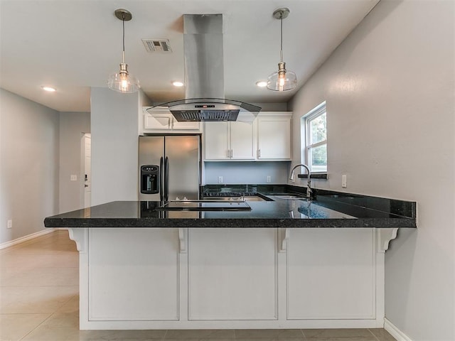 2248 NW 22nd St, Oklahoma City, OK 73107 - kitchen featuring island exhaust hood, stainless steel fridge, a peninsula, white cabinets, and black electric cooktop