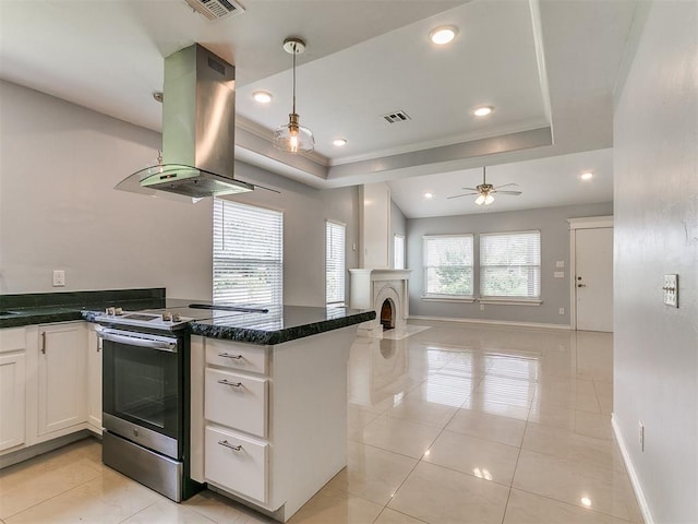 2248 NW 22nd St, Oklahoma City, OK 73107 - kitchen featuring stainless steel range with electric stovetop, island exhaust hood, a tray ceiling, white cabinets, and open floor plan
