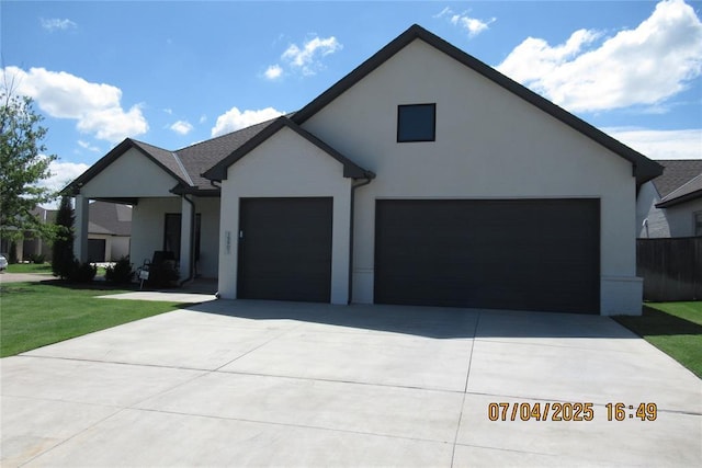 15901 Sarno Ln, Edmond, OK 73013 - view of front of home featuring a garage, concrete driveway, stucco siding, and a front yard