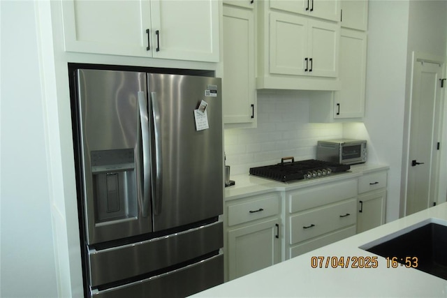 15901 Sarno Ln, Edmond, OK 73013 - kitchen featuring stainless steel appliances, light countertops, tasteful backsplash, and white cabinetry