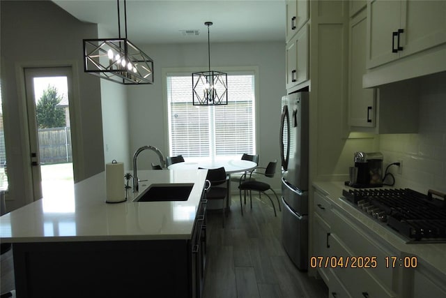 15901 Sarno Ln, Edmond, OK 73013 - kitchen featuring appliances with stainless steel finishes, a chandelier, light countertops, and plenty of natural light