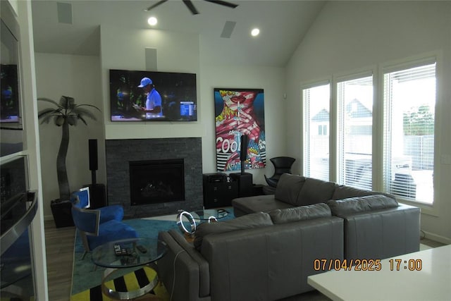 15901 Sarno Ln, Edmond, OK 73013 - living area featuring healthy amount of natural light, vaulted ceiling, wood finished floors, a stone fireplace, and ceiling fan