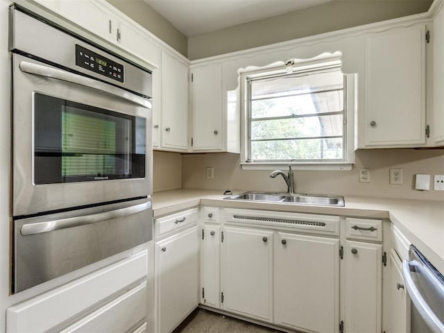 119 Thompson Dr, Moore, OK 73160 - kitchen featuring a warming drawer, dishwasher, light countertops, and white cabinets