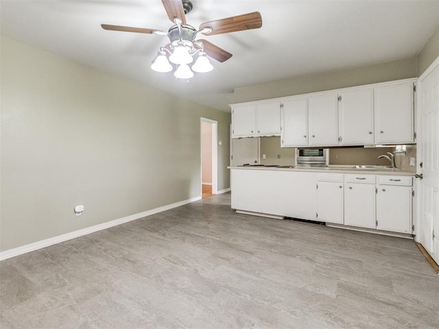 119 Thompson Dr, Moore, OK 73160 - kitchen with white cabinetry, ceiling fan, and light countertops