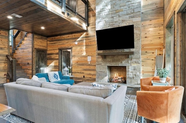 2105 Pine Hills Rd, Broken Bow, OK 74728 - living room with wooden walls, stairs, a stone fireplace, wooden ceiling, and wood finished floors