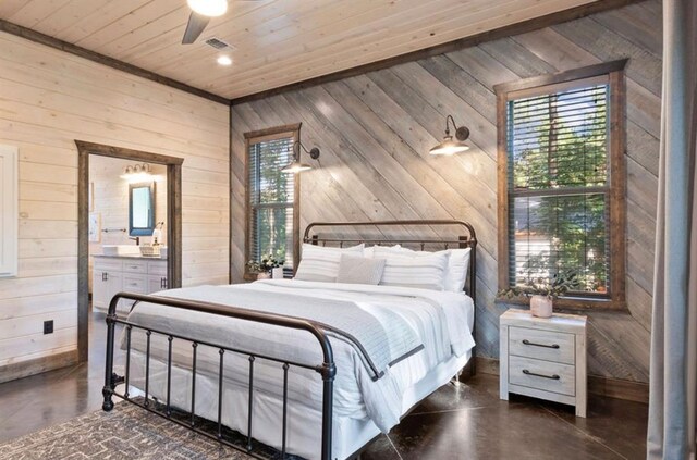 2105 Pine Hills Rd, Broken Bow, OK 74728 - bedroom with wooden walls, finished concrete floors, wood ceiling, ensuite bath, and a ceiling fan