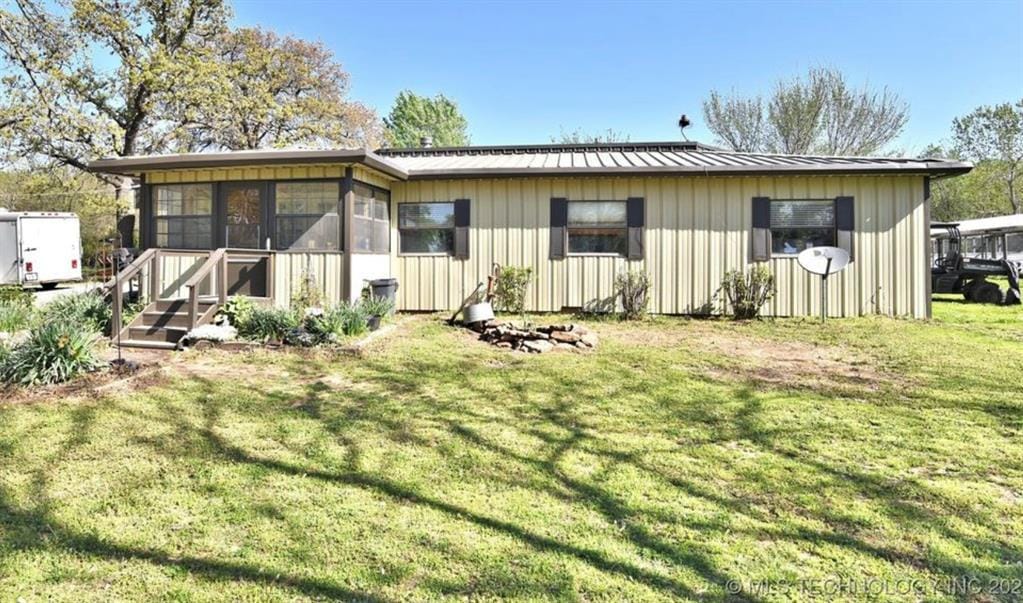 20536 S 417th W Ave, Bristow, OK 74010 - rear view of property with a yard, a metal roof, and a sunroom