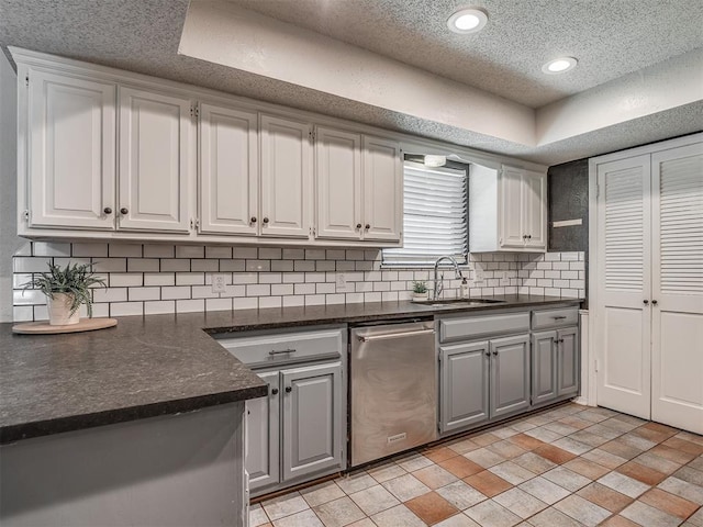 4812 Hunton Ter, Yukon, OK 73099 - kitchen featuring stainless steel dishwasher, gray cabinets, dark countertops, decorative backsplash, and a textured ceiling