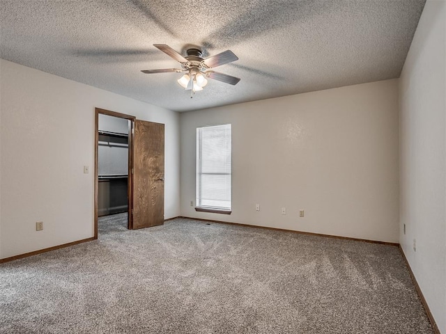 4812 Hunton Ter, Yukon, OK 73099 - unfurnished bedroom featuring carpet floors, a spacious closet, ceiling fan, and a textured ceiling