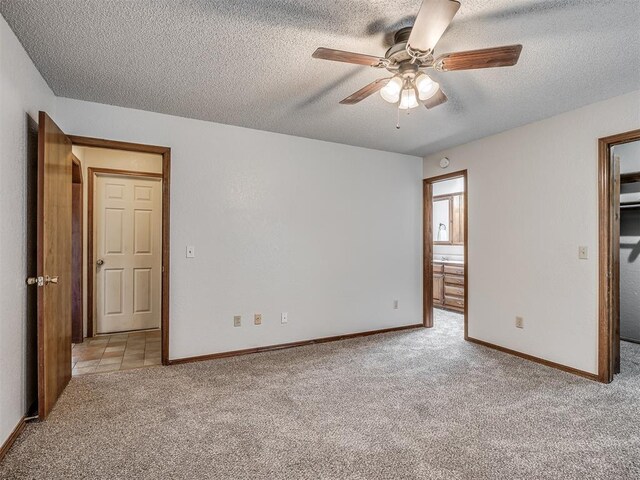 4812 Hunton Ter, Yukon, OK 73099 - unfurnished bedroom featuring carpet, a textured ceiling, a walk in closet, a ceiling fan, and connected bathroom