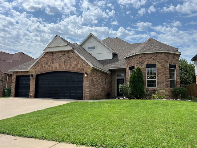 1016 Erinova Dr, Yukon, OK 73099 - view of front of home with roof with shingles, brick siding, a garage, and driveway