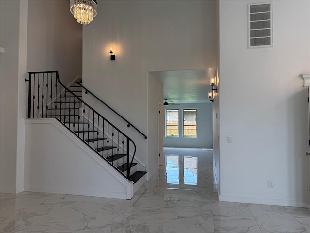 1016 Erinova Dr, Yukon, OK 73099 - stairs featuring marble look tiles, a chandelier, and a ceiling fan