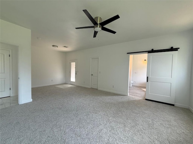 1016 Erinova Dr, Yukon, OK 73099 - unfurnished living room featuring light colored carpet, a ceiling fan, and a barn door