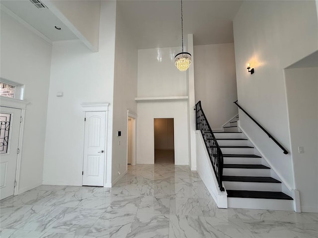1016 Erinova Dr, Yukon, OK 73099 - foyer entrance with a towering ceiling, stairs, marble look tile flooring, and a chandelier