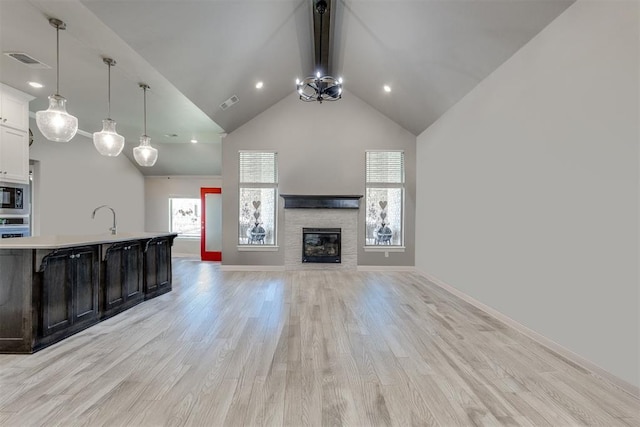 1624 NE 32nd St, Moore, OK 73160 - unfurnished living room featuring light wood finished floors, high vaulted ceiling, a fireplace, recessed lighting, and beam ceiling