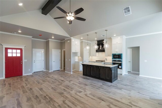 1624 NE 32nd St, Moore, OK 73160 - kitchen featuring stainless steel oven, black microwave, premium range hood, high vaulted ceiling, and ceiling fan