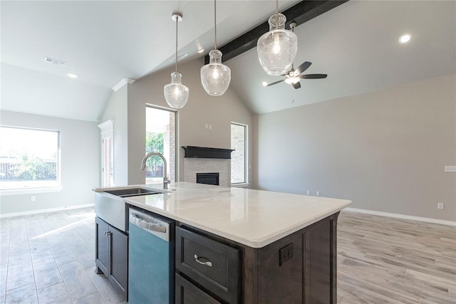 1624 NE 32nd St, Moore, OK 73160 - kitchen with dishwashing machine, open floor plan, a ceiling fan, a center island with sink, and a stone fireplace
