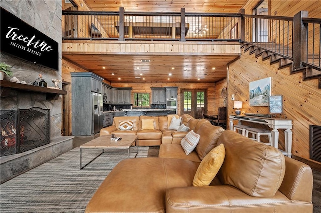 229 Sweet Gum Trl, Broken Bow, OK 74728 - living area with wooden walls, a large fireplace, wooden ceiling, and a towering ceiling