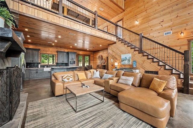 229 Sweet Gum Trl, Broken Bow, OK 74728 - living area featuring wood walls, recessed lighting, a high ceiling, stairs, and concrete floors