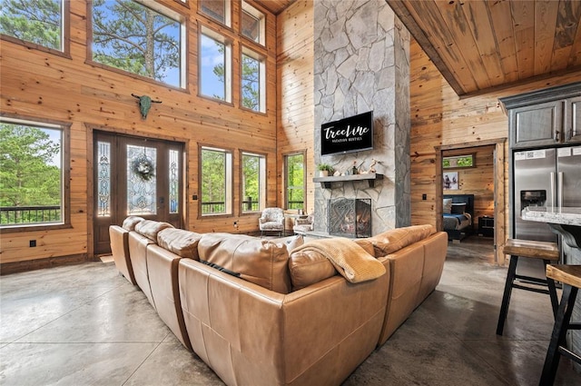 229 Sweet Gum Trl, Broken Bow, OK 74728 - living area with wood walls, a towering ceiling, healthy amount of natural light, concrete flooring, and wood ceiling