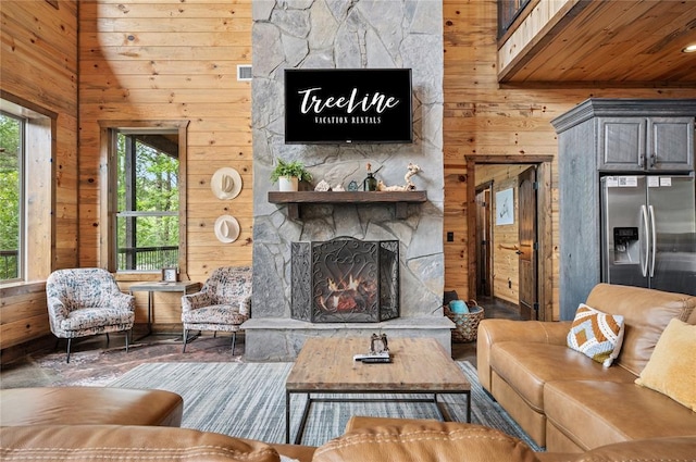 229 Sweet Gum Trl, Broken Bow, OK 74728 - living area with wooden walls, a stone fireplace, plenty of natural light, wood finished floors, and wooden ceiling