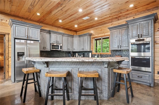 229 Sweet Gum Trl, Broken Bow, OK 74728 - kitchen with appliances with stainless steel finishes, finished concrete floors, wood ceiling, decorative backsplash, and recessed lighting