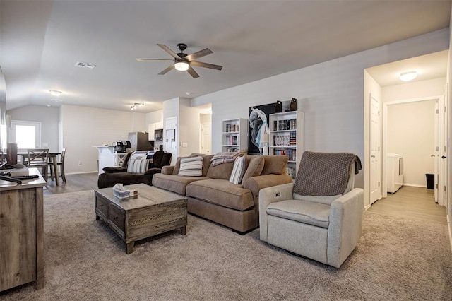 11725 Casey Dr, Yukon, OK 73099 - living area with ceiling fan, washer / dryer, vaulted ceiling, and light colored carpet