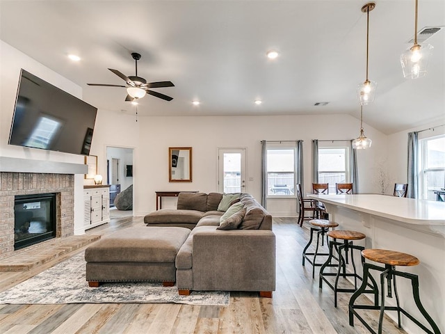 6516 SE 87th St, Oklahoma City, OK 73135 - living area featuring light wood finished floors, a fireplace, a ceiling fan, vaulted ceiling, and recessed lighting