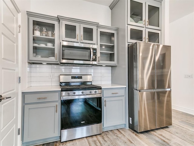 6516 SE 87th St, Oklahoma City, OK 73135 - kitchen featuring appliances with stainless steel finishes, gray cabinets, light countertops, light wood-style flooring, and tasteful backsplash