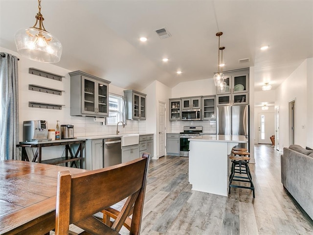6516 SE 87th St, Oklahoma City, OK 73135 - kitchen with stainless steel appliances, gray cabinetry, decorative backsplash, light countertops, and vaulted ceiling