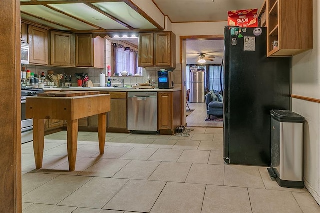 2317 N Redmond Ave, Bethany, OK 73008 - kitchen featuring appliances with stainless steel finishes, backsplash, a ceiling fan, light countertops, and brown cabinets