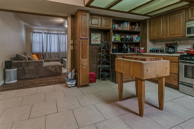 2317 N Redmond Ave, Bethany, OK 73008 - kitchen featuring stainless steel appliances, light countertops, open shelves, light tile patterned floors, and decorative backsplash